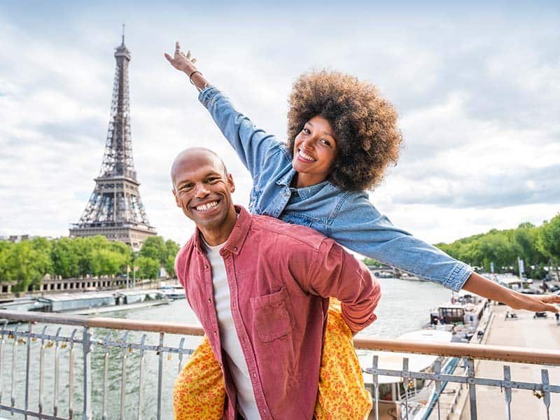 Happy couple posing for a photo against Eiffel tower